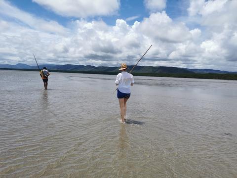 two people walk on a beach